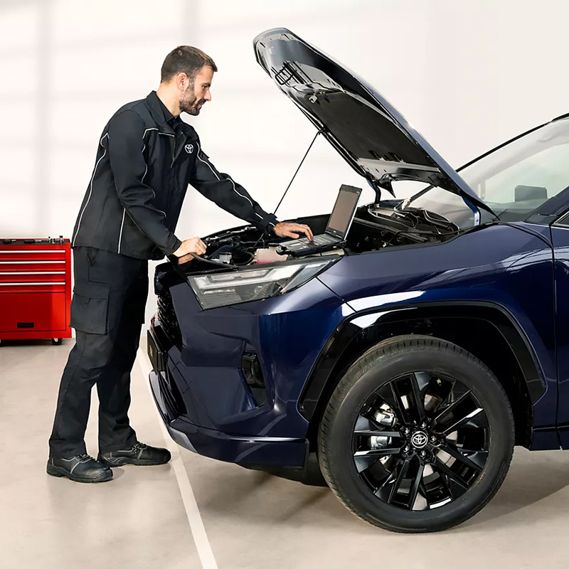 Mann am Fahrzeug mit offener Motorhaube
